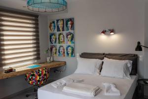 a bedroom with a bed with white sheets and a window at Acropolis Monastiraki Newly Renovated Apartment in Athens