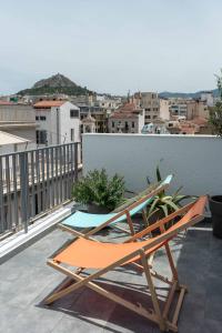 a couple of chairs sitting on a balcony at Acropolis Monastiraki Newly Renovated Apartment in Athens