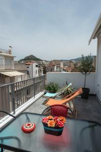 a table with a bowl of flowers on a balcony at Acropolis Monastiraki Newly Renovated Apartment in Athens