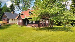 a large house with a tree in the yard at Chalupa Severak in Janov nad Nisou