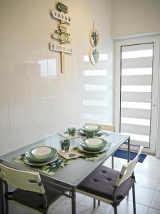 a dining room with a glass table and chairs at Viana Lovers in Viana do Castelo