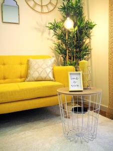 a yellow couch in a living room with a table at Viana Lovers in Viana do Castelo