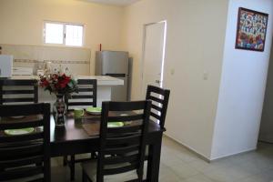 a dining room and kitchen with a table and chairs at Residencial Gran Santa Fe Cancun in Cancún