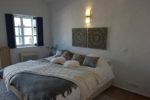 1 dormitorio con 1 cama con manta y ventana en The Enchanted farm en Almancil