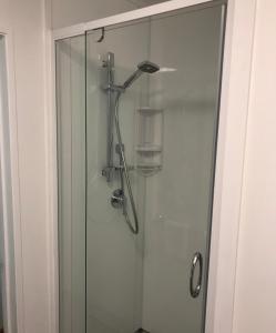 y baño con ducha y puerta de cristal. en Cascades Motor Lodge en Auckland