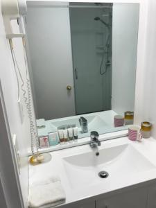 a bathroom with a sink and a large mirror at Cascades Motor Lodge in Auckland