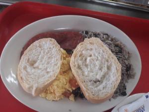 ein weißer Teller mit einem Sandwich und Reis in der Unterkunft Hotel Costa del Sol in Puerto Limón