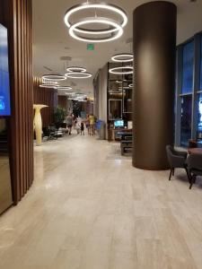 an empty lobby with chairs and tables and a hallway with people at C y H Residences Hyde in Hollywood