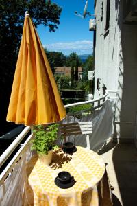 żółty parasol siedzący na stole na balkonie w obiekcie Studio Apartman PIC w mieście Nijvice