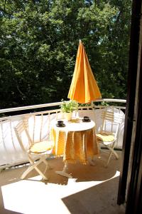 stół i krzesła z parasolem na balkonie w obiekcie Studio Apartman PIC w mieście Nijvice