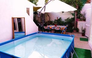a swimming pool in a yard with a table and an umbrella at La Maison dos Prazeres in Portimão