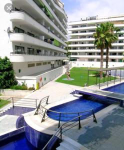 un edificio con piscina di fronte a un edificio di Bonito y Acogedor Apartamento con fibra a Salou