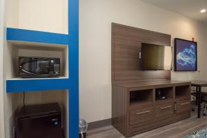 ein Wohnzimmer mit einem TV und einem Tisch in einem Zimmer in der Unterkunft Palace Inn El Paso in El Paso