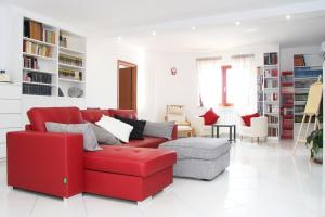 un divano rosso e una sedia in soggiorno di MarArte B&B a Trecase