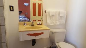 a bathroom with a sink and a toilet and a mirror at Deluxe Motel, Los Angeles Area in Downey