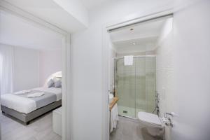a white bathroom with a bed and a shower at Ossuna Bay Hotel Boutique in Cefalù +37 photos