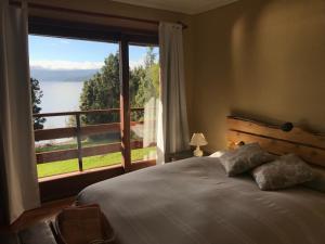 una camera da letto con un letto e una grande finestra di Las Juntas Ecolodge a Puyehue