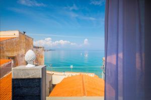 een uitzicht op de oceaan vanuit een raam van een gebouw bij Ossuna Bay Hotel Boutique in Cefalù