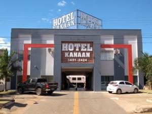 un hotel kamman con coches estacionados frente a él en Hotel Kanaan, en Pimenta Bueno