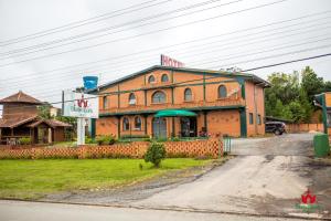 a large brick building with a sign in front of it at Hotel Blumenpark in Rio Negro