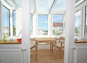 アールベックにあるWohnung Sanke Seeblickの窓と木製テーブル付きのダイニングルーム