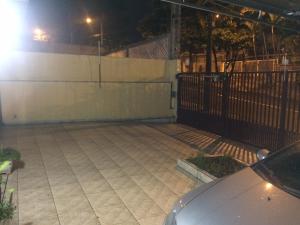 un estacionamiento vacío por la noche con una valla en Casa Familiar em Campinas com 2 Quartos, 1 banheiro, 1 vaga para carro, en Campinas