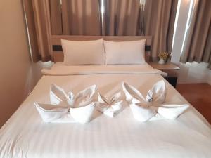 a white bed with three white flowers on it at Nice Sea Resort in Srithanu