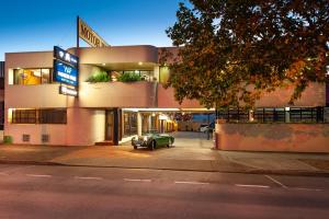 a car parked on the side of a street next to a building at Winsor Park Motor Inn in Albury