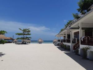 a beach with umbrellas and the ocean in the background at Nice Sea Resort in Srithanu