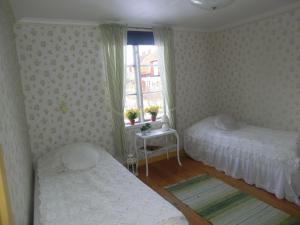 a bedroom with two beds and a window at Karlstugan Cottage in Vimmerby