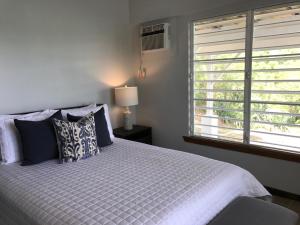 um quarto com uma cama com almofadas e uma janela em Oceania Villas em Culebra
