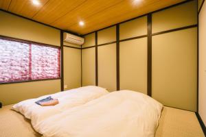 um quarto com uma cama grande e uma janela em Miro Kujo Kawaramachi Tei em Quioto