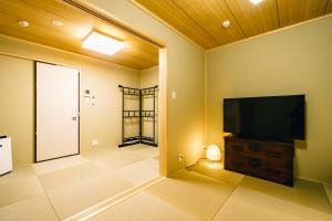 uma sala de estar com uma televisão de ecrã plano num armário em Miro Kujo Kawaramachi Tei em Quioto
