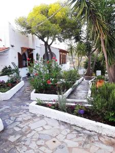 a garden with flowers and trees and a building at Apollonion Apartment Aigina in Perdhika