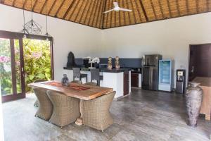 een keuken met een tafel, stoelen en een koelkast bij Villa Michiko in Uluwatu
