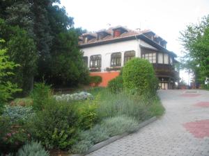 uma casa com um jardim em frente em Krisztina Panzió em Balatonalmádi