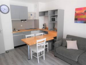 uma cozinha e sala de estar com uma mesa e um sofá em Appartement 4p luchon cures & ski Soda em Luchon