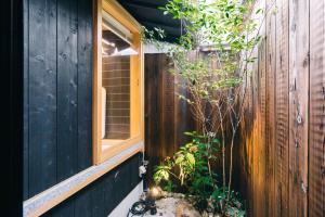 drewniany płot z oknem i rośliną w obiekcie Miro Hachijo Genmachi Tei w mieście Kioto