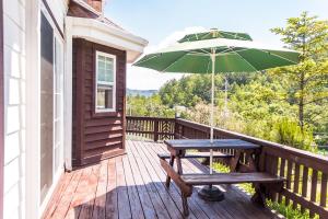 a wooden deck with a picnic table and an umbrella at Sunny House in Pyeongchang