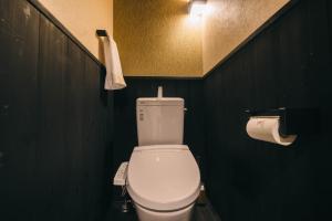 a bathroom with a white toilet in a black wall at Miro Sanjo Umemiyacho Tei in Kyoto +16 photos