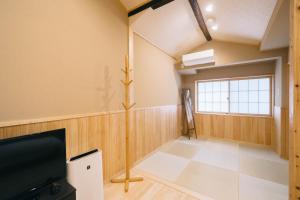 a living room with a tv and a window at Miro Saiinnishi Imadacho Tei in Kyoto