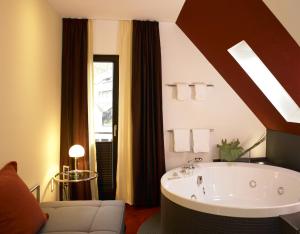 ein Bad mit einer großen Badewanne in einem Zimmer in der Unterkunft Hotel Antoniushütte in Balve