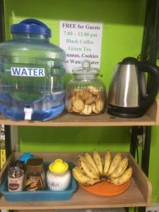 a shelf with a bowl of bananas and a jug of water at i-smile & U2 Hostel in Chiang Mai