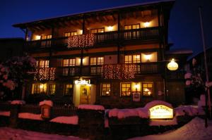 un edificio con luces de Navidad en la nieve por la noche en Pension Zur Alten Schmiede, en Zwiesel