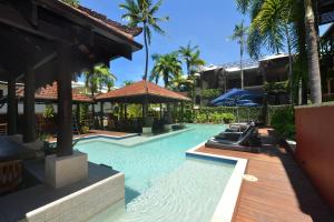 a swimming pool in a resort with palm trees at Seascape Holidays - Hibiscus in Port Douglas