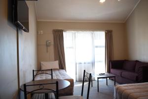 a living room with a bed and a couch at Devonwood Motel in Rotorua