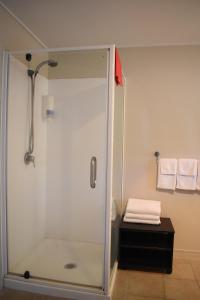 a shower with a glass door in a bathroom at Devonwood Motel in Rotorua +28 photos