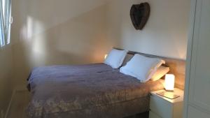Saint-Fort-sur-GirondeにあるLe Bananierのベッドルーム1室(白い枕2つ付きのベッド1台付)
