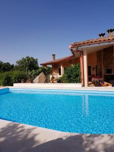 a swimming pool in front of a house at Casa Mariluka in Capoterra