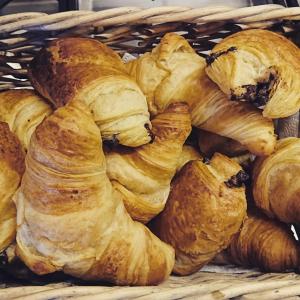 a basket filled with croissants and other pastries at Chalet La Moussière in Saint-Jean-d'Aulps